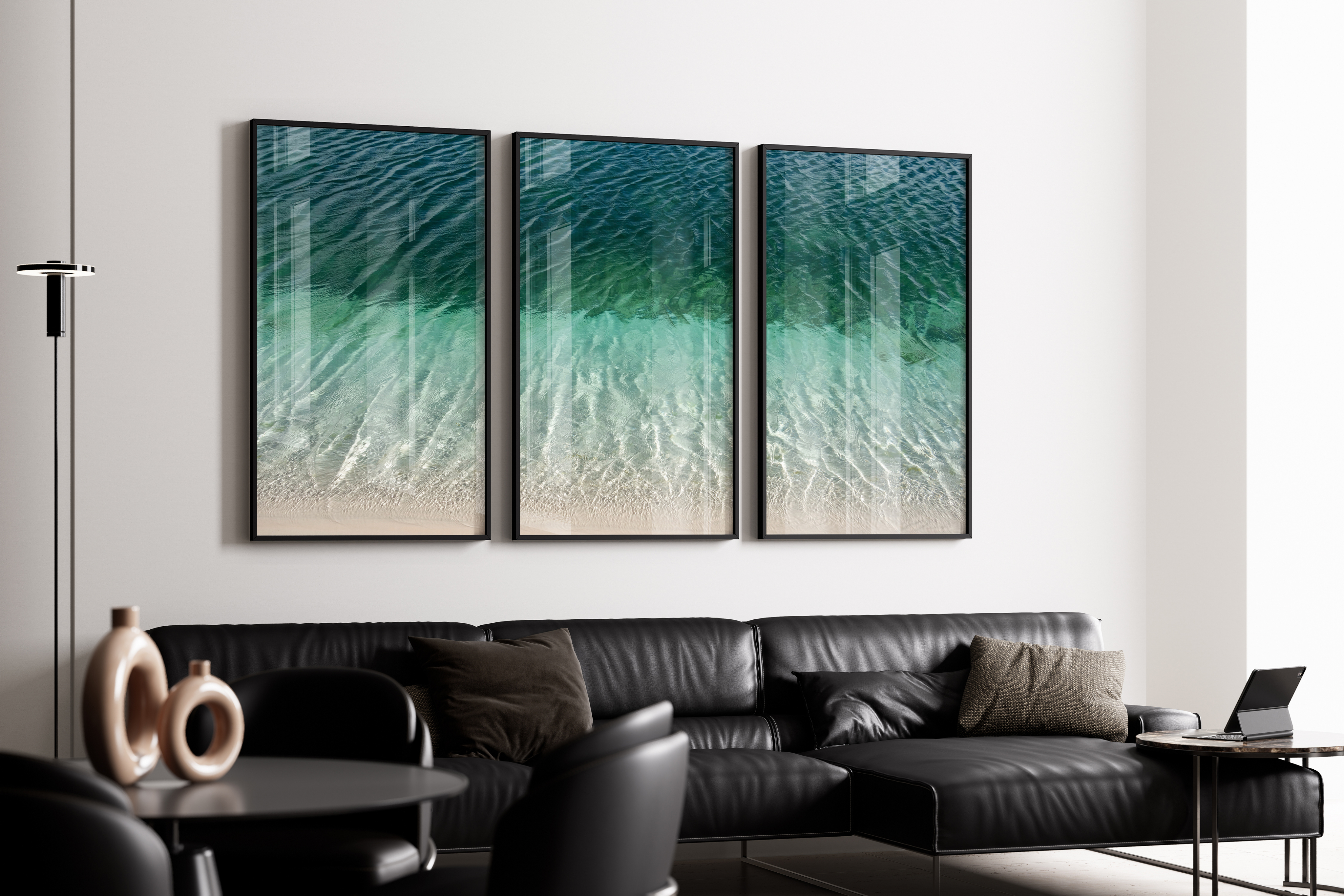 Ambiente com sofá preto e quadros do mar